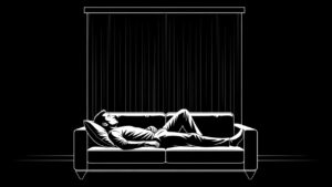 Black and white image of a man lying awake on a couch at night, unable to sleep