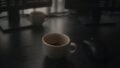 Espresso cups remaining on an office desk between computer monitors