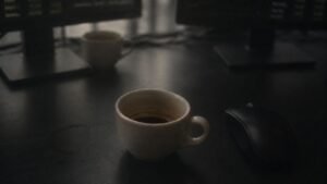 Espresso cups remaining on an office desk between computer monitors