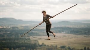 A tightrope walker balancing with a long pole while crossing a suspended rope